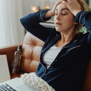 a lady is putting her hand on her head.