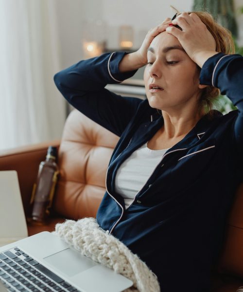 a lady is putting her hand on her head.