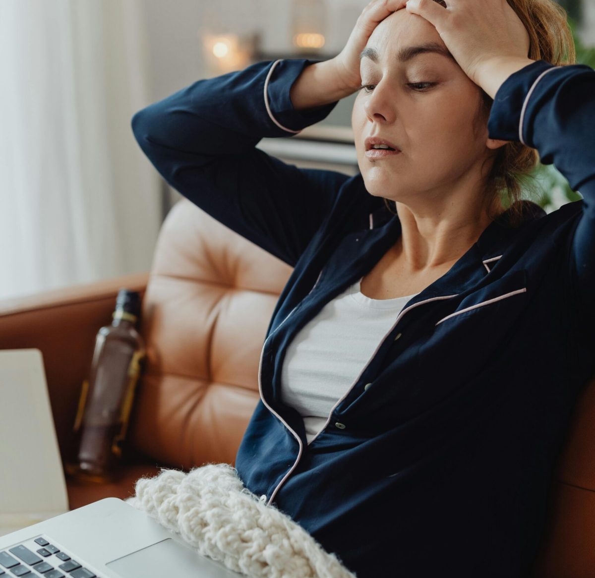 a lady is putting her hand on her head.